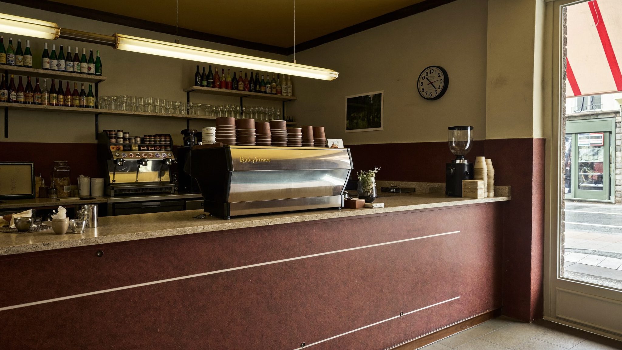 Tejghea de cafenea lustruită și luminoasă, gata pentru prima tură